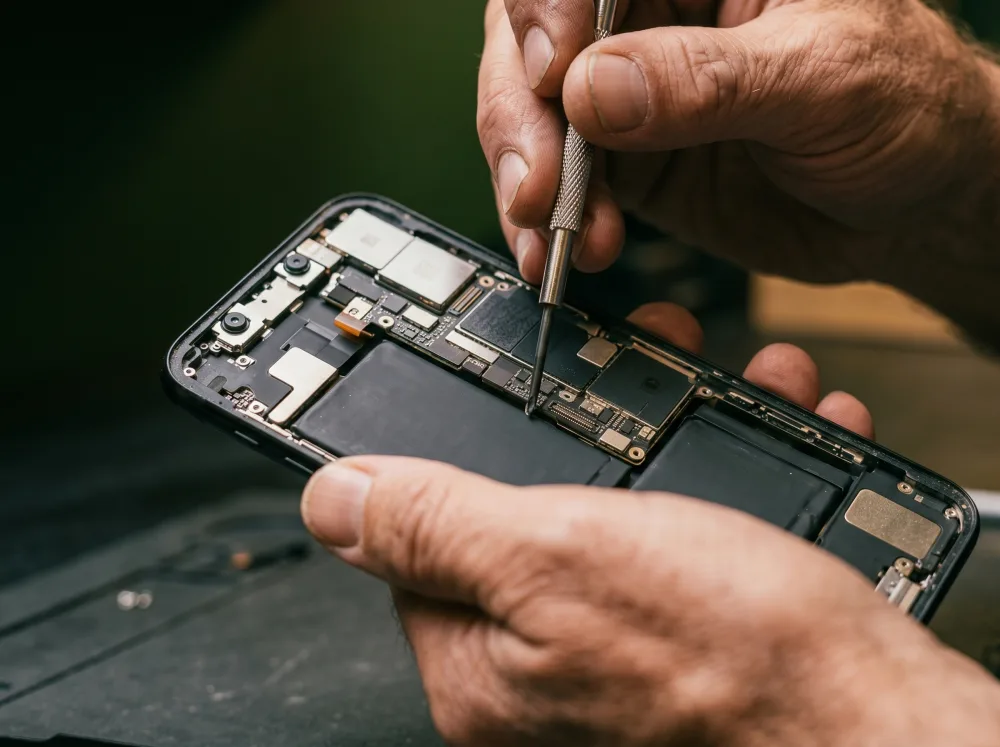 Precision work on an opened smartphone – Reparo technician with specialist tools