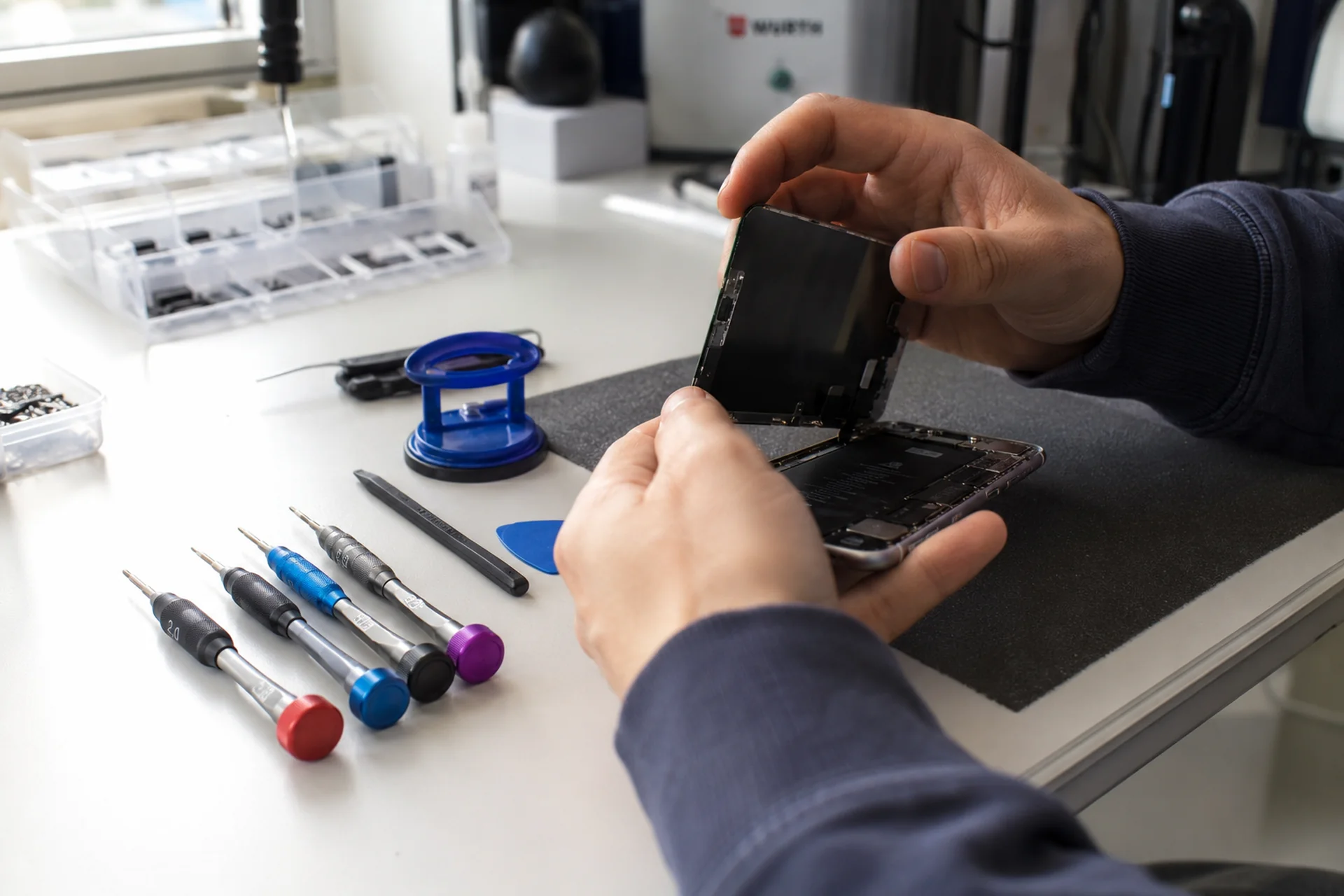 iPhone Reparatur Display Kosten — verschiedene iPhone-Modelle nebeneinander mit Festpreis-Schildern